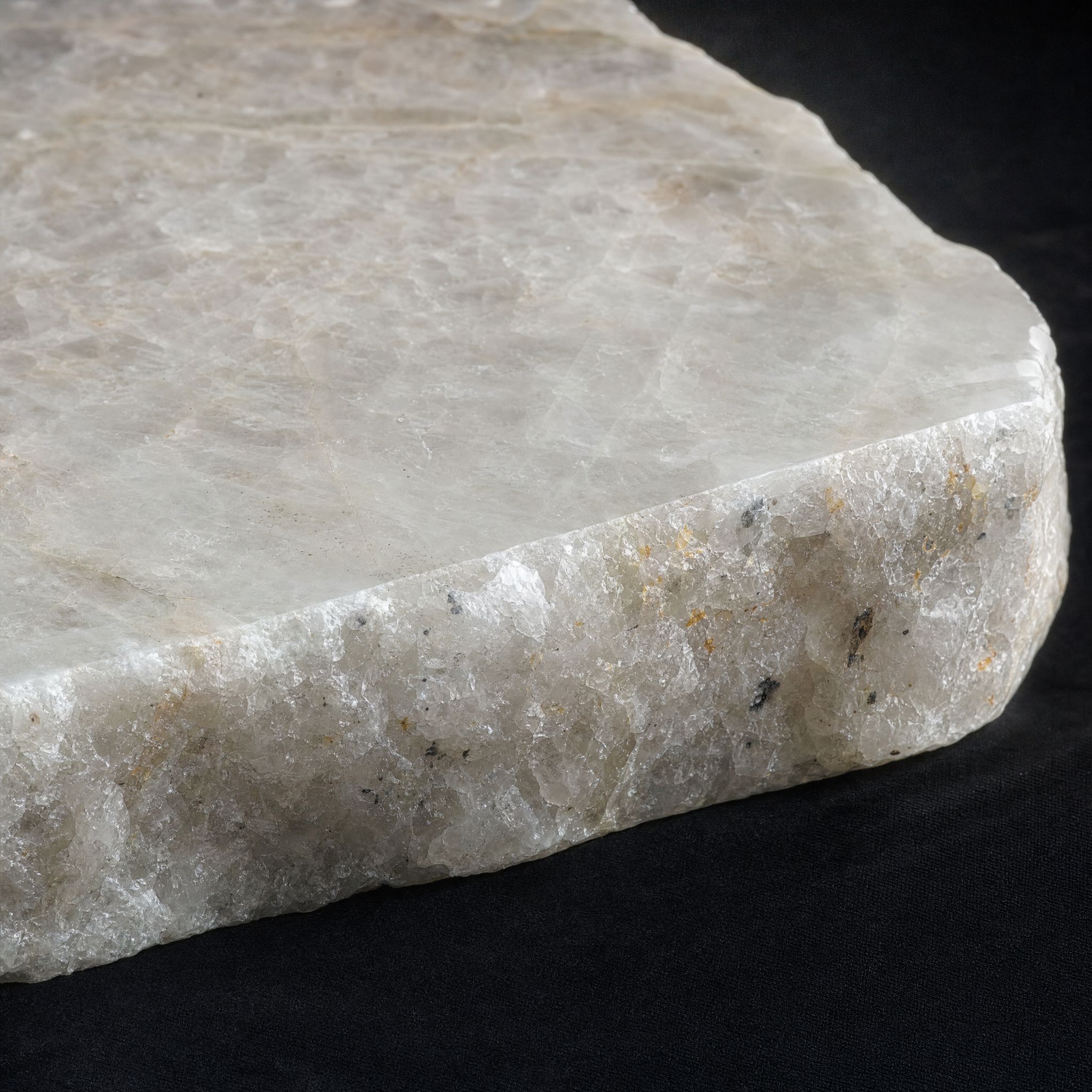 Milky crystalline Cristallo quartzite with a rough sawn edge and fine amber inclusions.