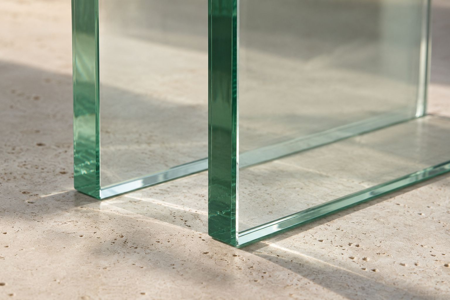 Clear architectural glass panels with polished green-tinted edges and soft reflections