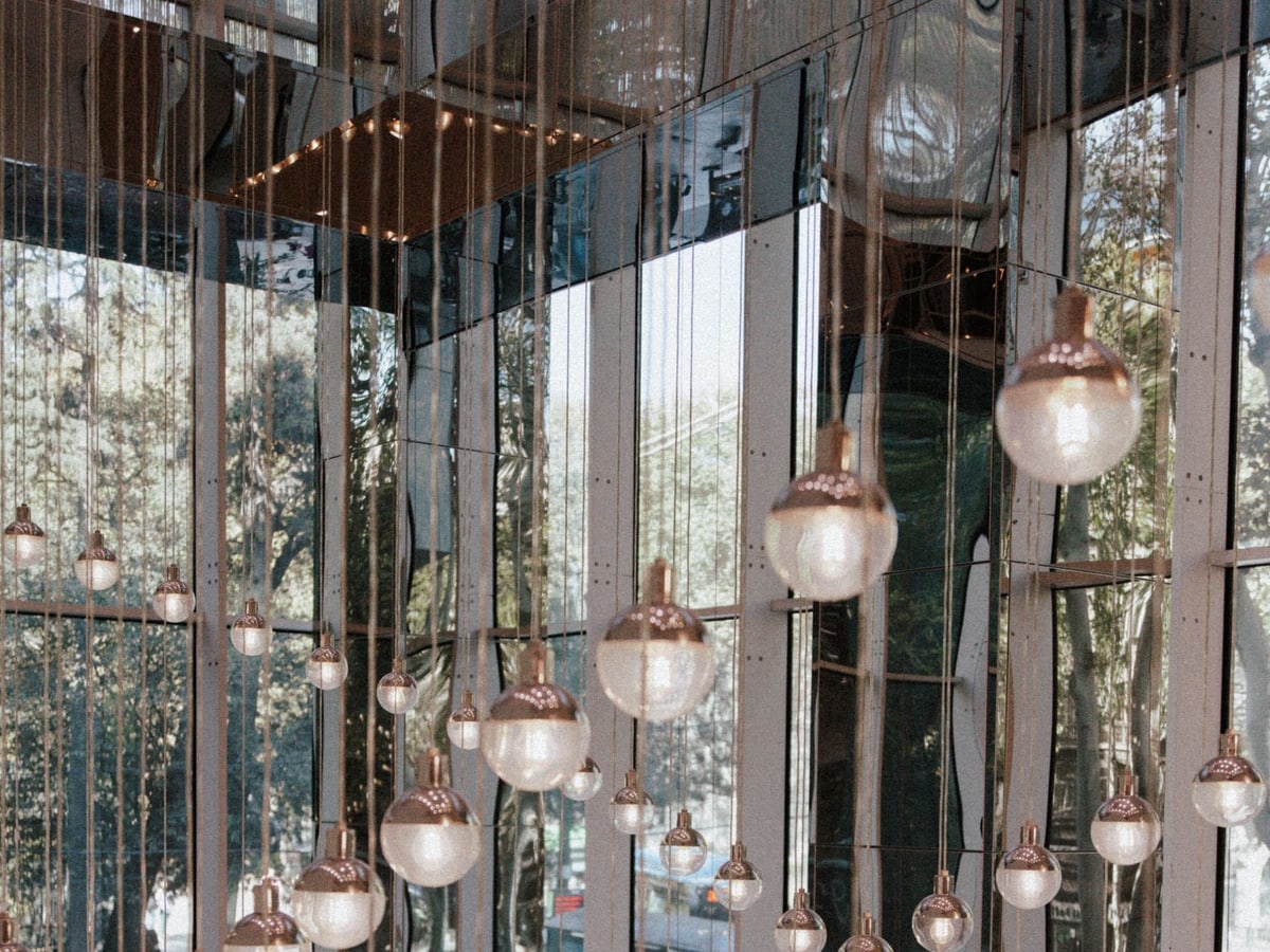 Sculptural glass pendant lights suspended at different heights in a modern interior