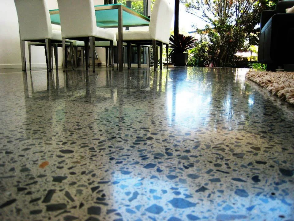 Polished concrete floor showing exposed stone aggregate and reflections in a dining room